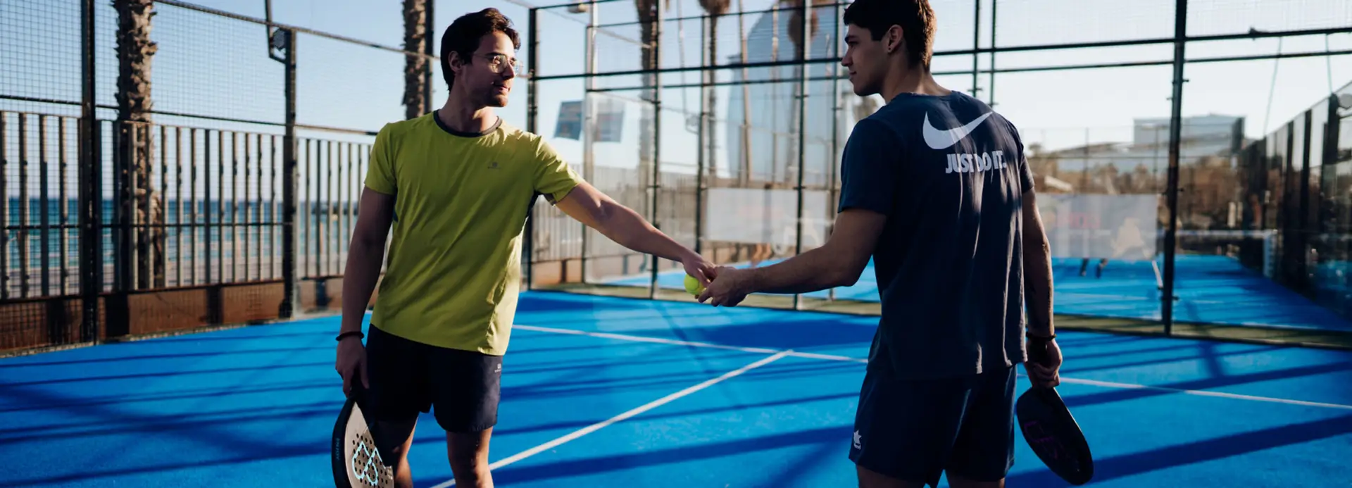 Men shaking hands on Club Natació Barcelona outdoor court