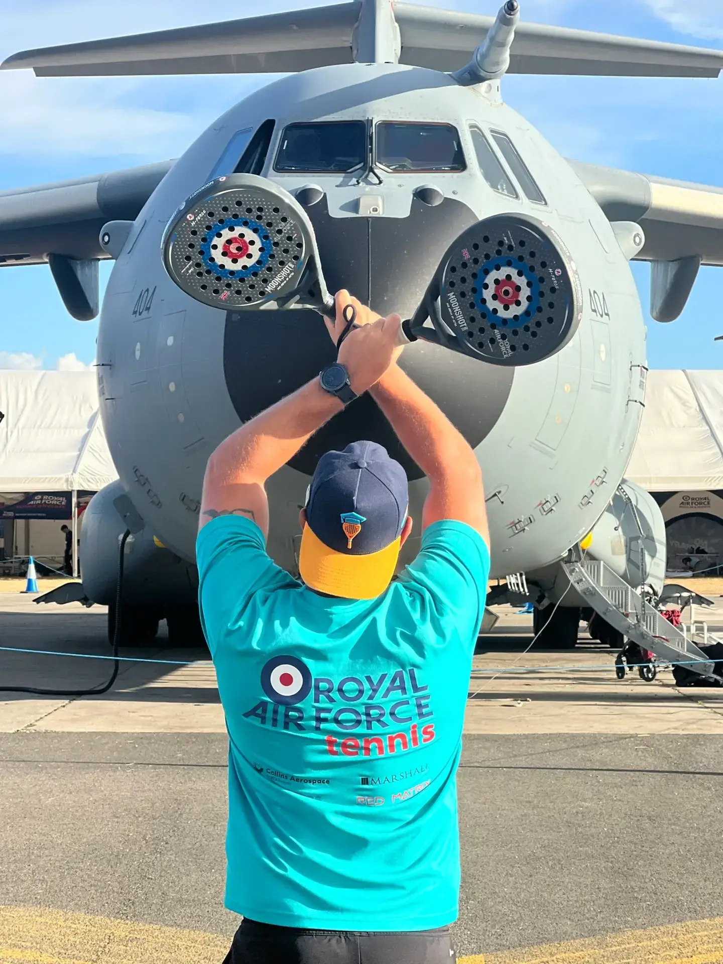 Ben from RAF Padel waving down aircraft with padel rackets