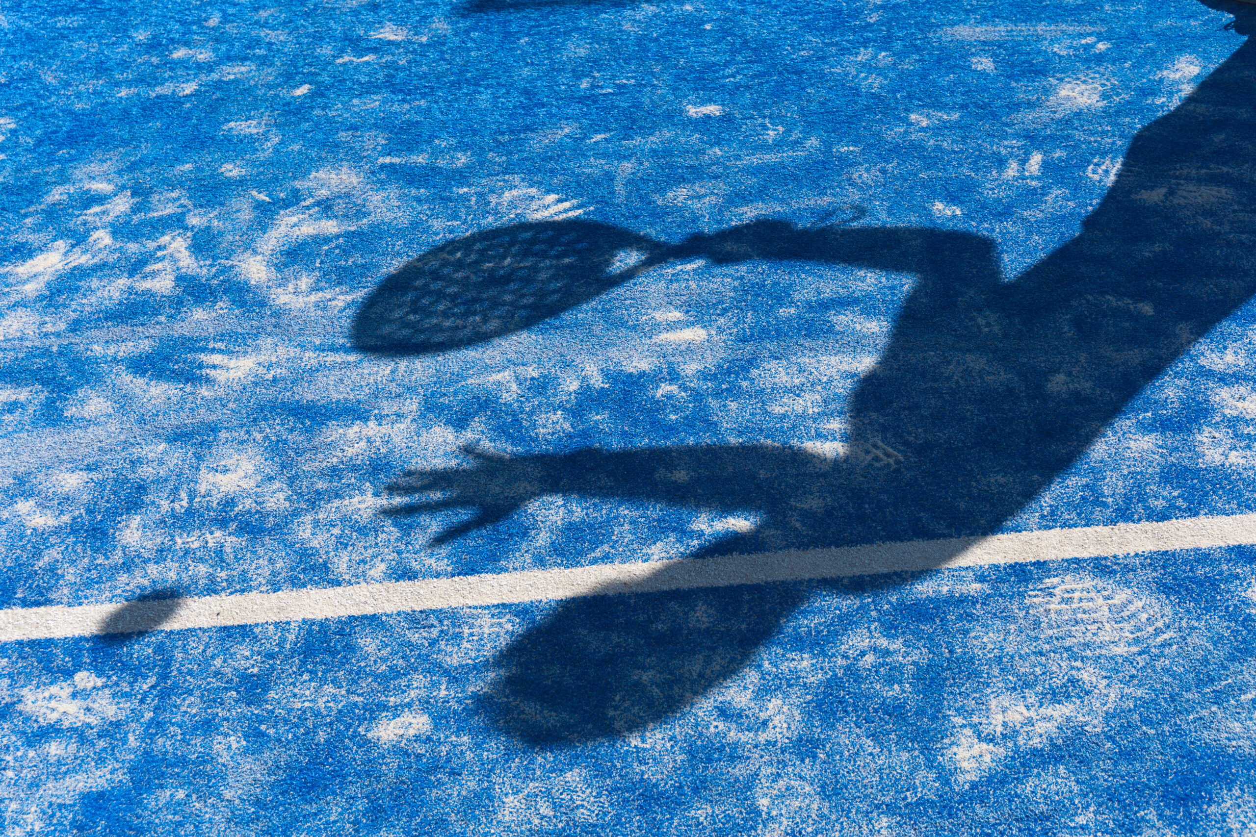 Shadow of man playing padel on court