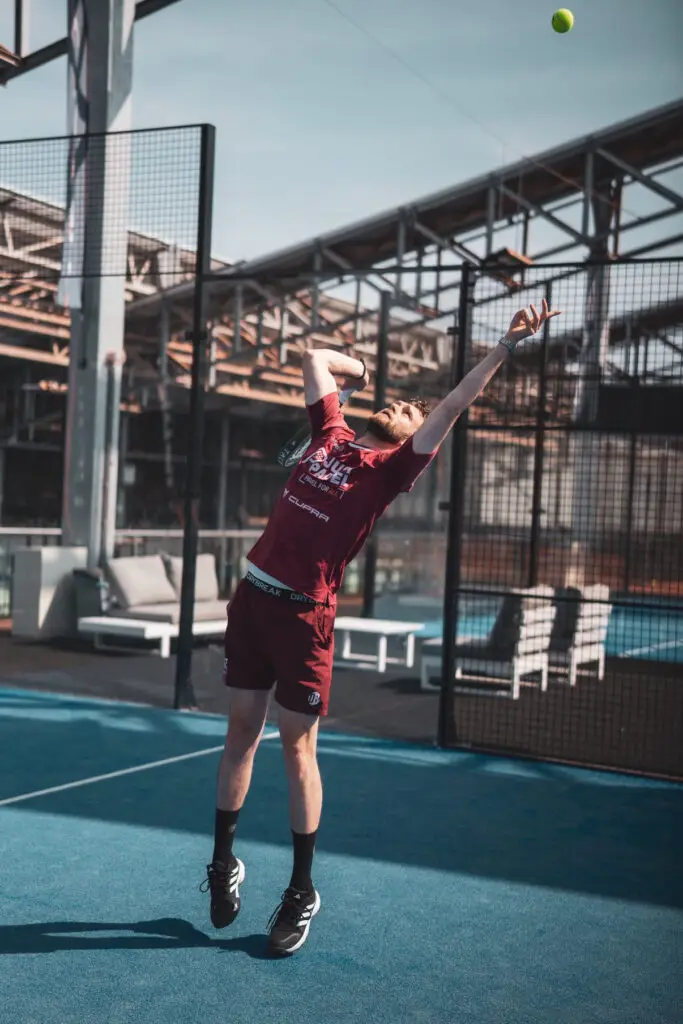 Sven Boele on padel court hitting a smash