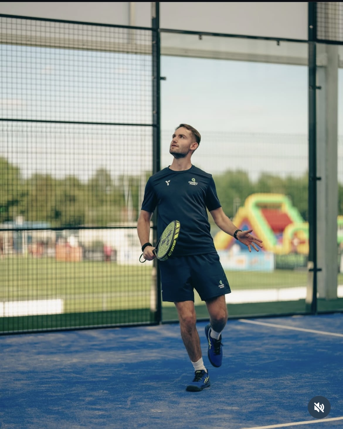 Harry Blundell on padel court hitting a ball