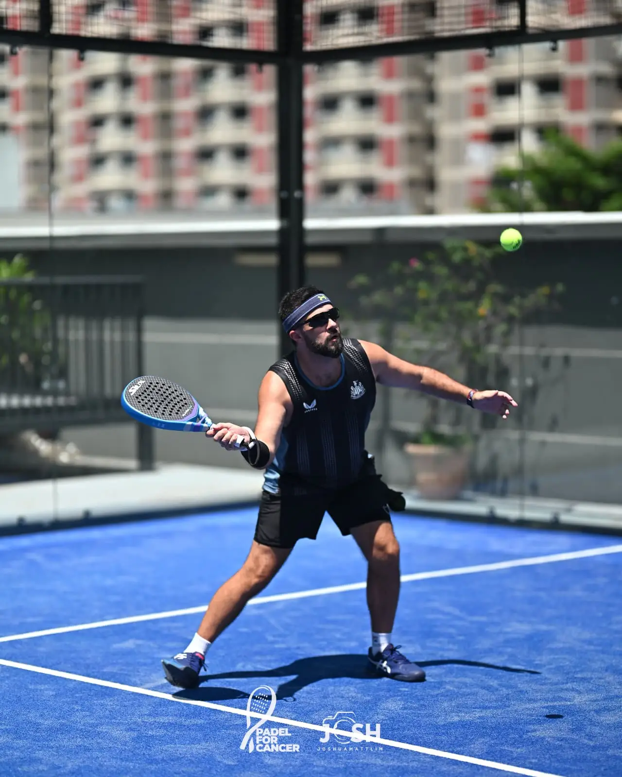 Marco on padel court hitting shot