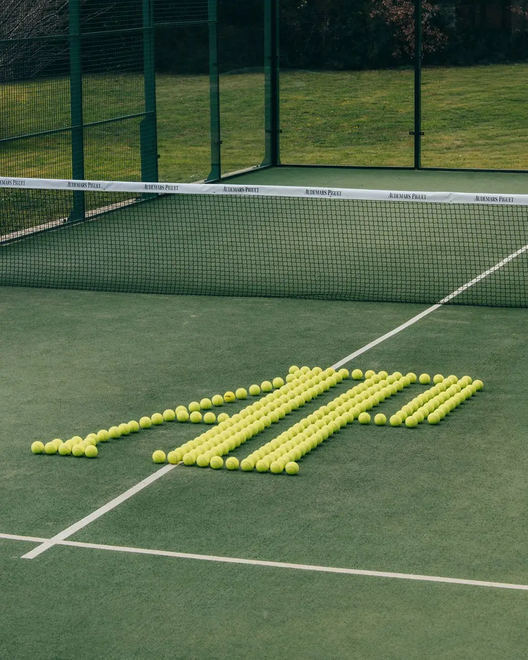 Balls on padel court arranged to spell AP