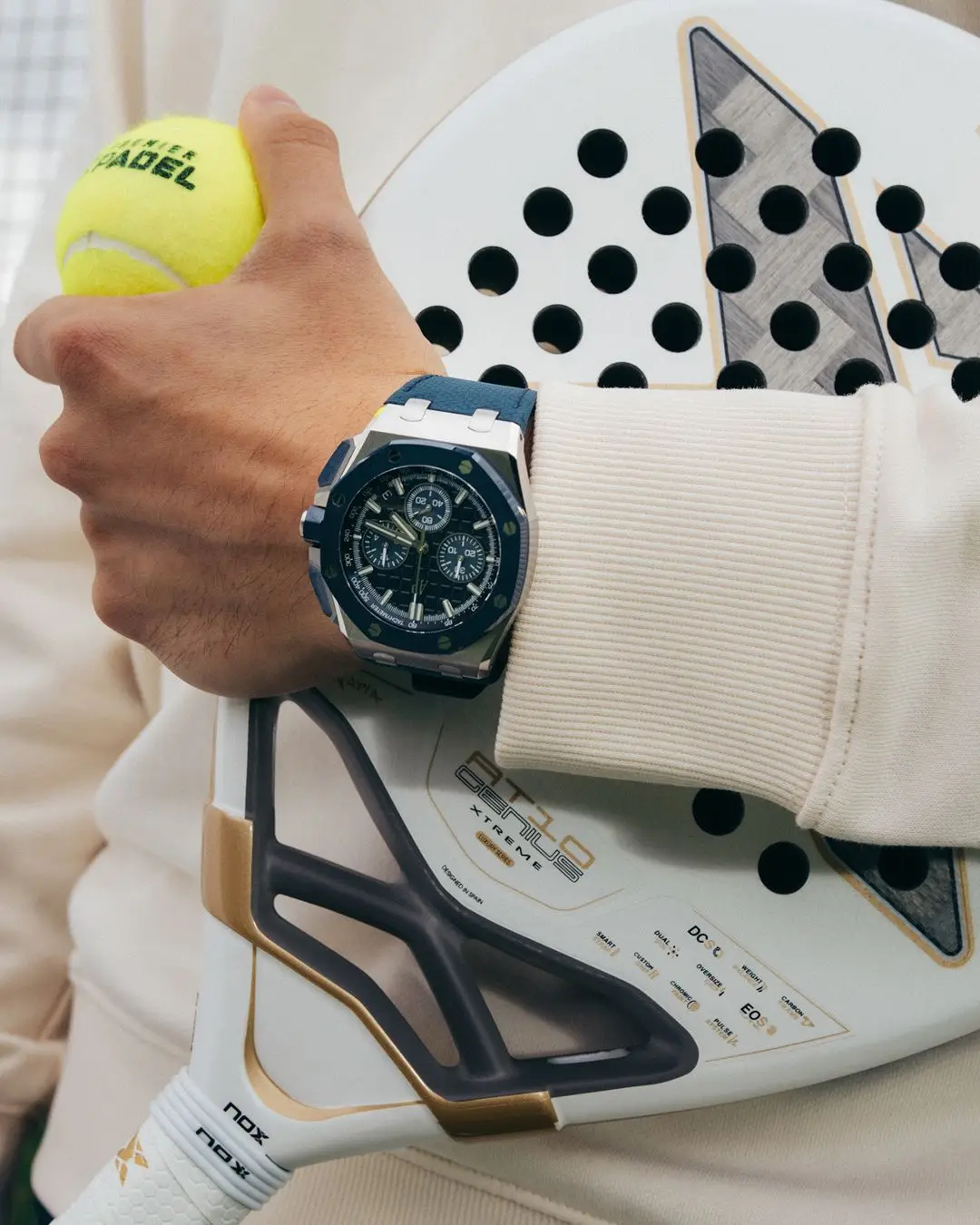 AP watch, premier padel ball, and racket held by a person