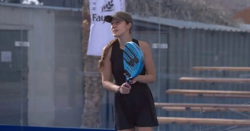 Anna Guryanova at the net during a tournament match, holding a blue padel racket