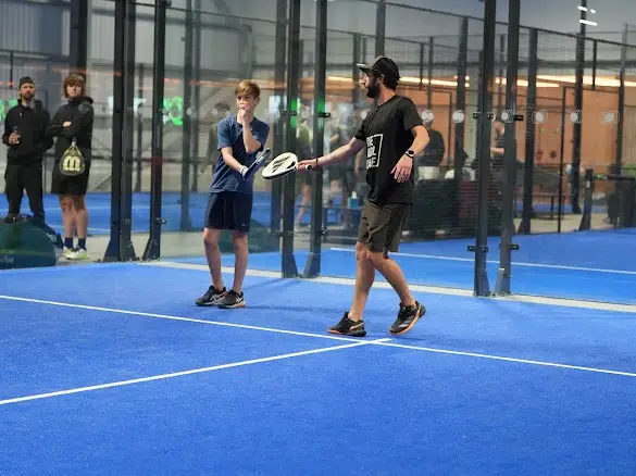 Jamie Guest coaching a young player on court