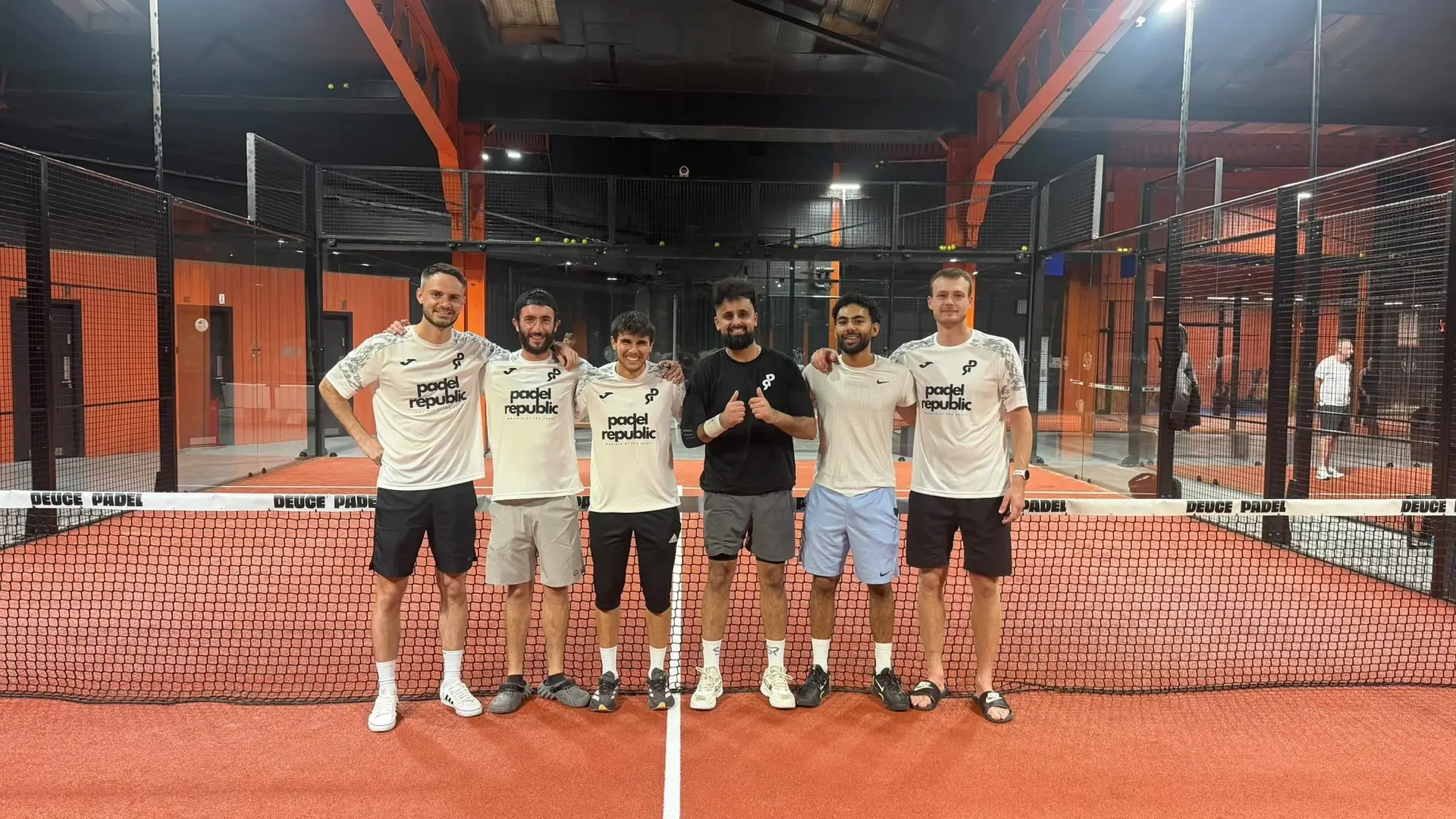 A group of padel players lined up on an indoor court