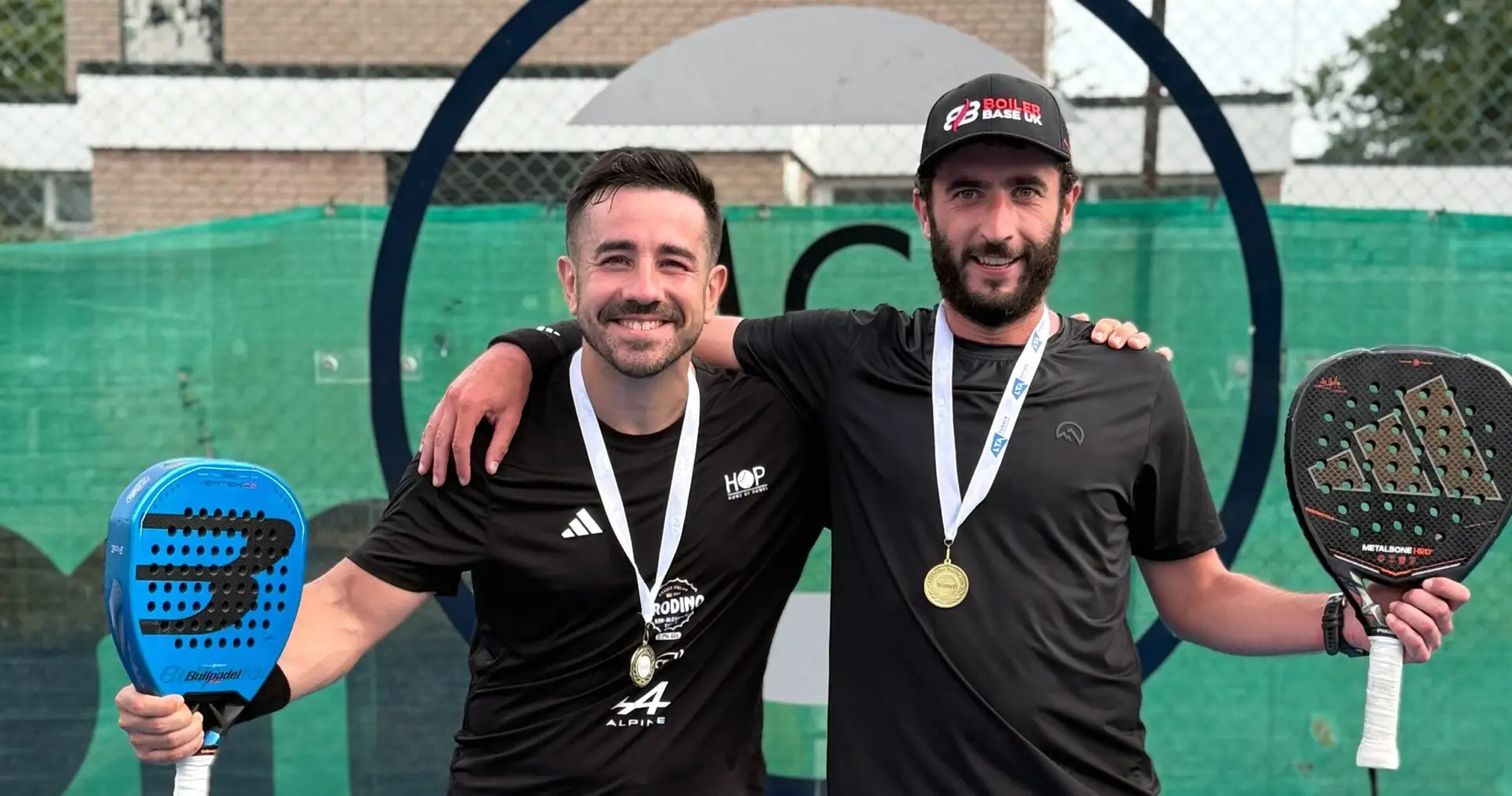 Jamie Guest and his doubles partner with tournament medals and padel rackets